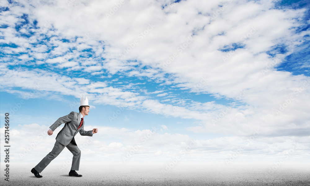King businessman in elegant suit running and blue sky at background King businessman in elegant suit running and blue sky at background