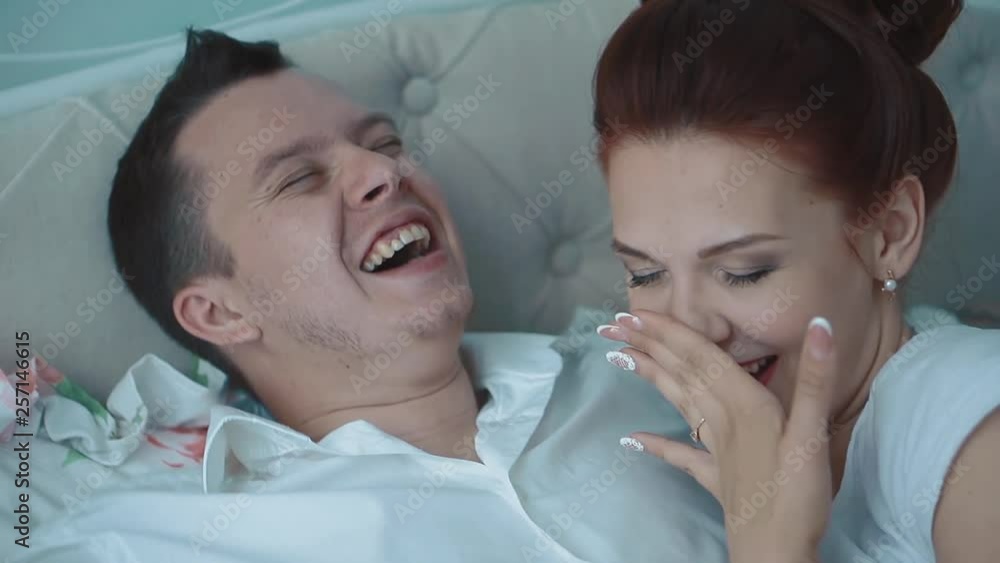Young couple resting in bed, laughing, yawning, close-up, slow motion Young couple resting in bed, laughing, yawning, close-up, slow motion