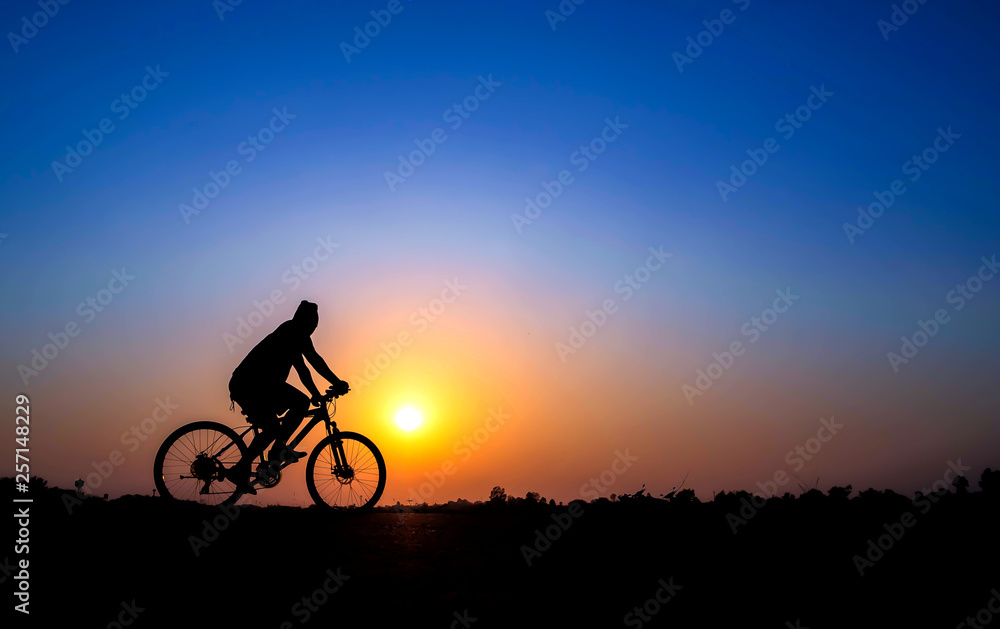 Obraz premium cyclist on sunset background