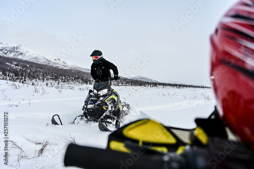Rider on Arctic Cat Snowmachine Snowmobile sledding in the mountains in Alaska