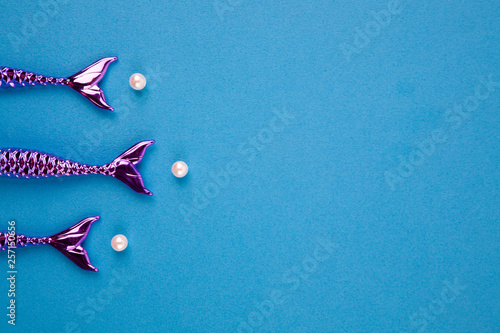 shiny tails of mermaids on a blue background