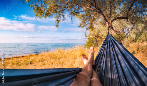 Photography Man lays in a hammock on a sea beach