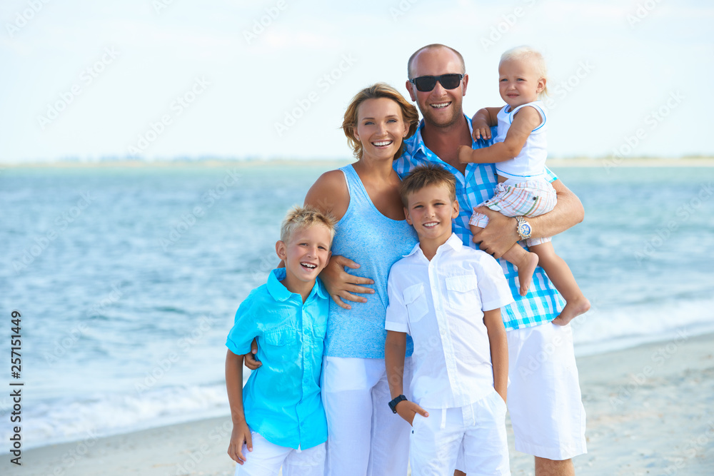 Happy family with kids standing on the beach. Happy family with kids standing on the beach.