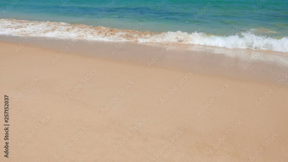 Medium wide view of waves hitting the shore at a beach during daytime Medium wide view of waves hitting the shore at a beach during daytime