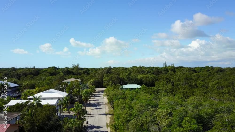 AERIAL: slow push and lift past suburban terrain to reveal more of Key Largo. AERIAL: slow push and lift past suburban terrain to reveal more of Key Largo.