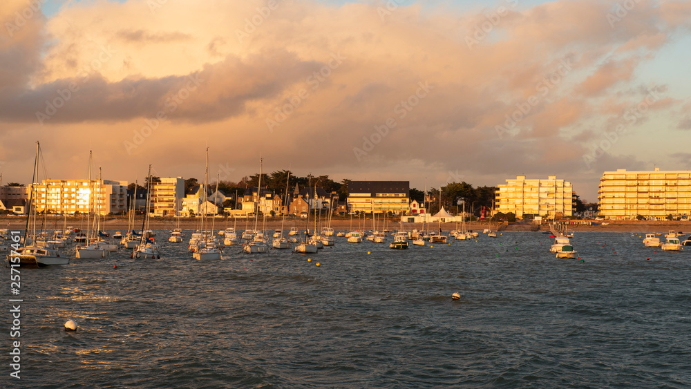 Pornichet shoreline at sunset with boats, beach, sea and buildings