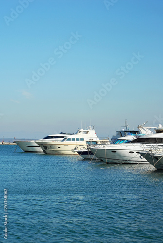 Many white yachts on the wharf. Elegant yachts on the background of the blue sky. © Ivan