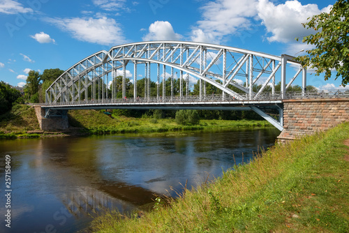 Borovichi, Russia - August 8, 2018: First in Russia steel arch bridge on river Msta in sunny summer day. Novgorod region, Borovichi, Russia. Was built in 1905.