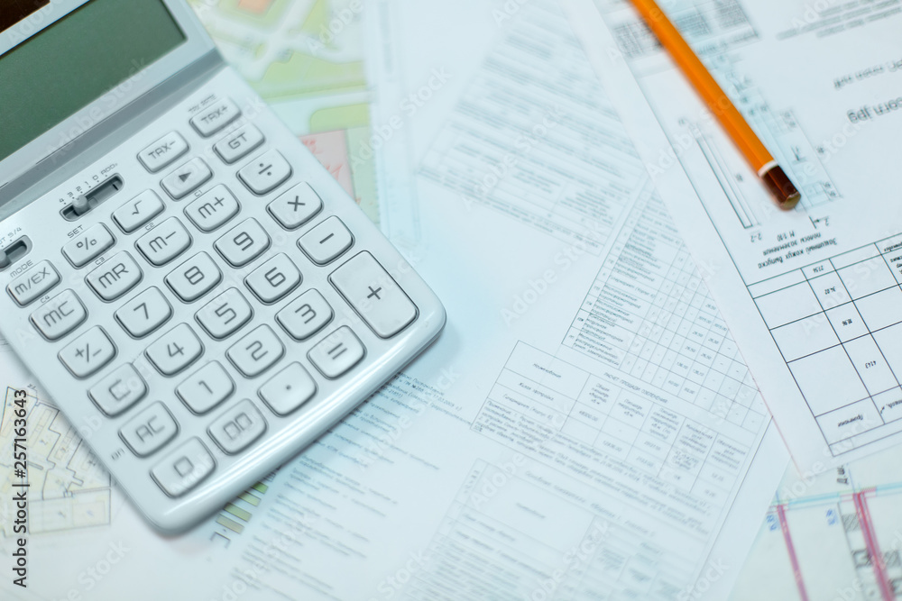 Rolled electrical diagrams, calculator, pencils and mathematical calculations for project, drawings for the projects engineer jobs Rolled electrical diagrams, calculator, pencils and mathematical calculations for project, drawings for the projects engineer jobs