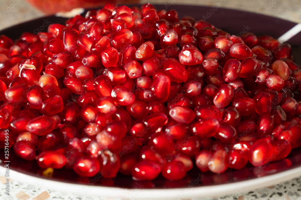 red ripe pomegranate seeds on a plate close-up. pomegranate fruit. healthy diet red ripe pomegranate seeds on a plate close-up. pomegranate fruit. healthy diet
