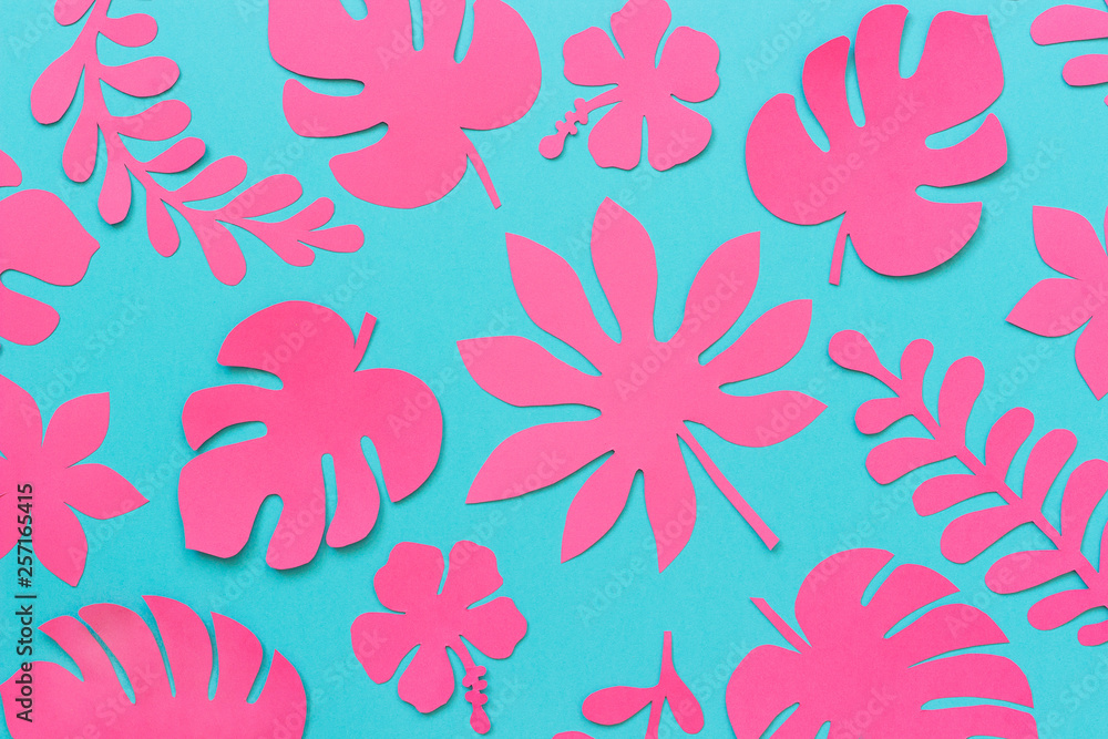 Tropical leaves pattern. Trendy pink tropical leaves of paper on blue background. Flat lay, top-down composition, creative paper art