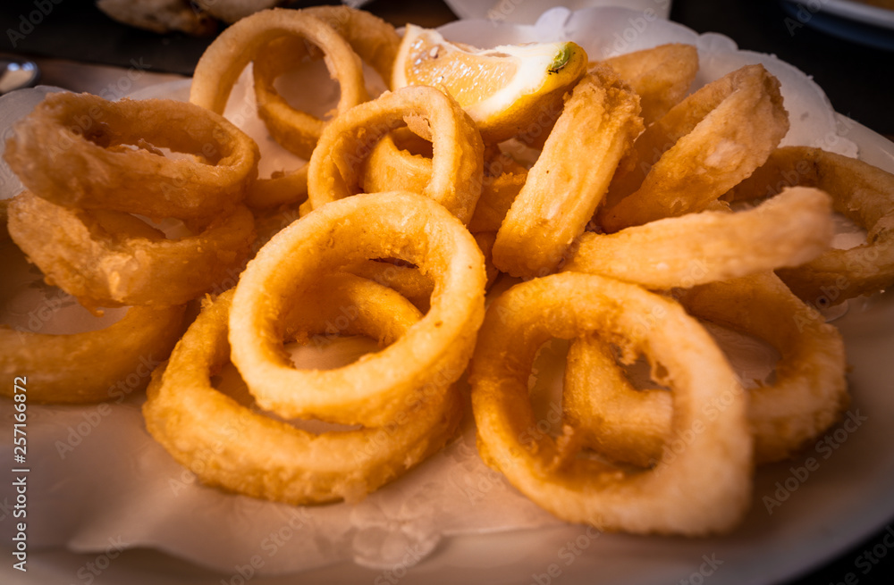 Spanish tapas: Plate of Roman-style squid or fried calamari with lemon. Typical spanish food Spanish tapas: Plate of Roman-style squid or fried calamari with lemon. Typical spanish food