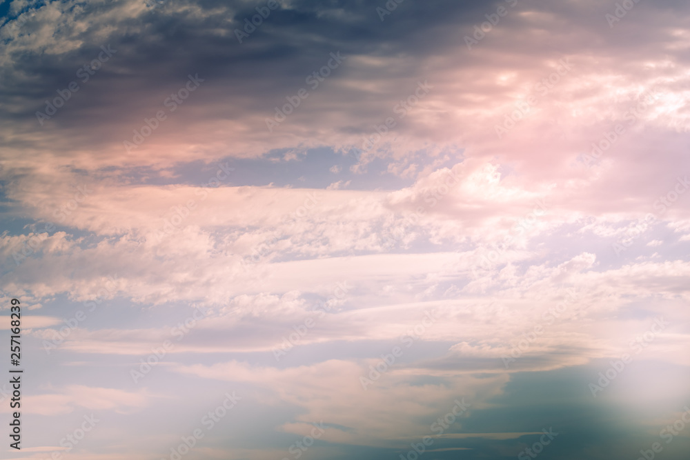 Naklejka premium Dramatyczne błękitne niebo z różowymi chmurami cumulus, soczewkowatymi i cirrus