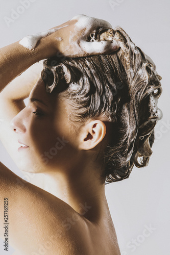 Side view of woman washing her blond hair.