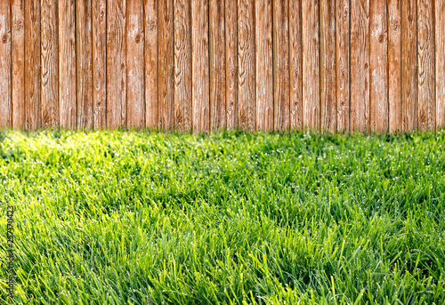 Wooden garden fence at backyard with green grass