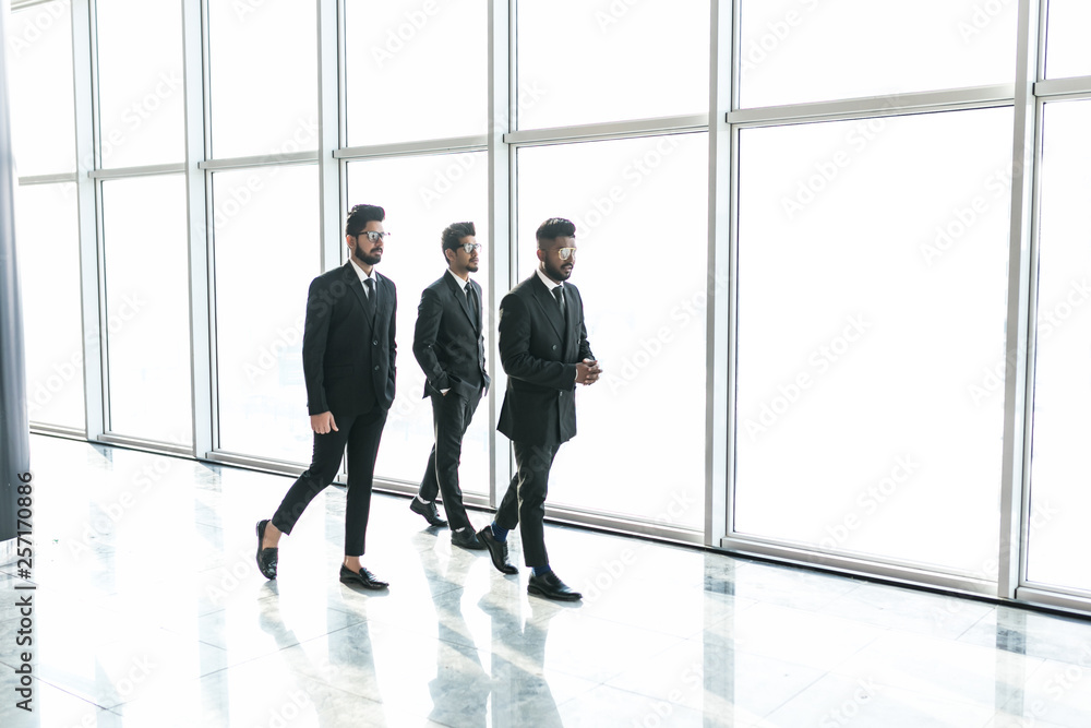 Fototapeta premium Businesspeople moving along the corridor with big panoramic windows