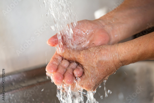Senior woman washing her hands, Flowing and Splashing water, Close up & Macro shot, Selective focus, Healthcare concept