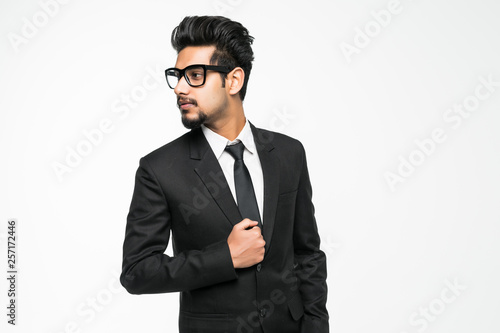 Handsome indian man in glasses standing against white background