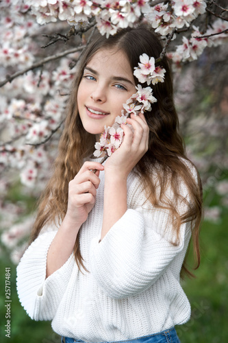 Beautiful girl in blossom almond garden. Gardening.