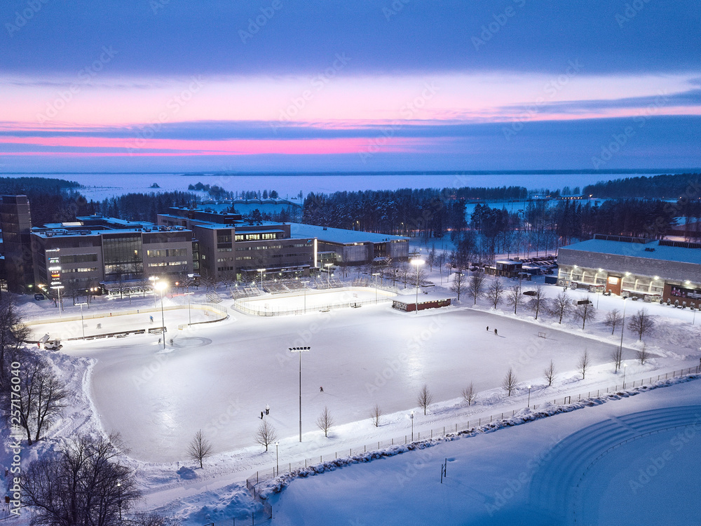Aerial view of a huge ice rink on the background of a beautiful sunset