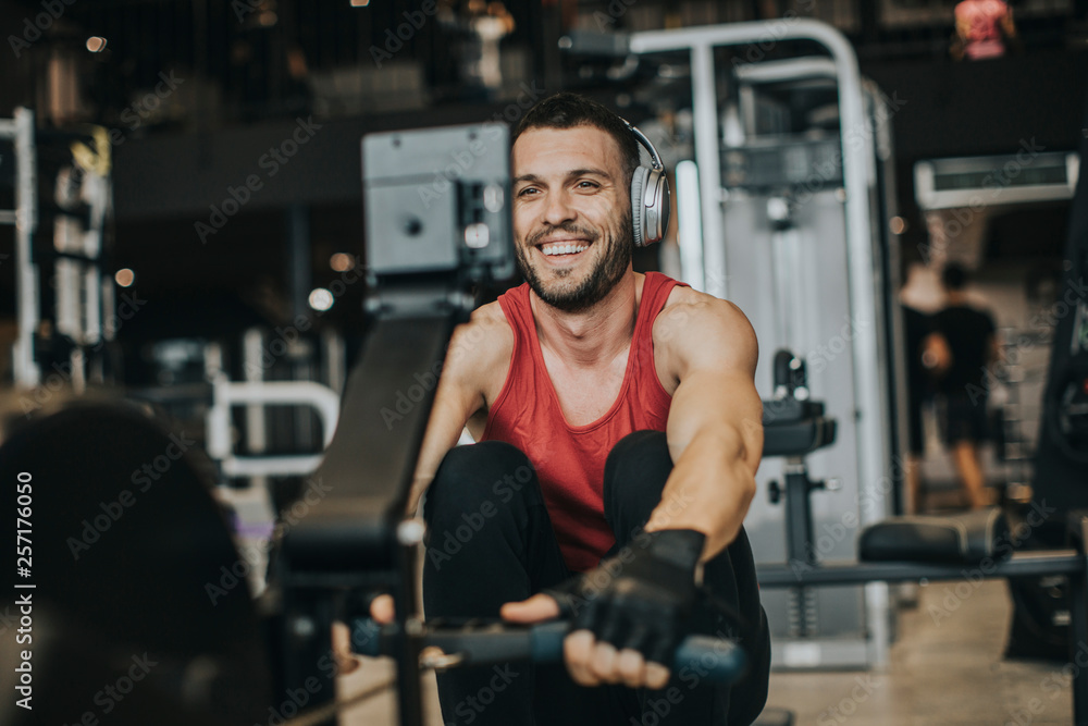 Young man doing workouts on a back with power exercise machine in a gym club Young man doing workouts on a back with power exercise machine in a gym club