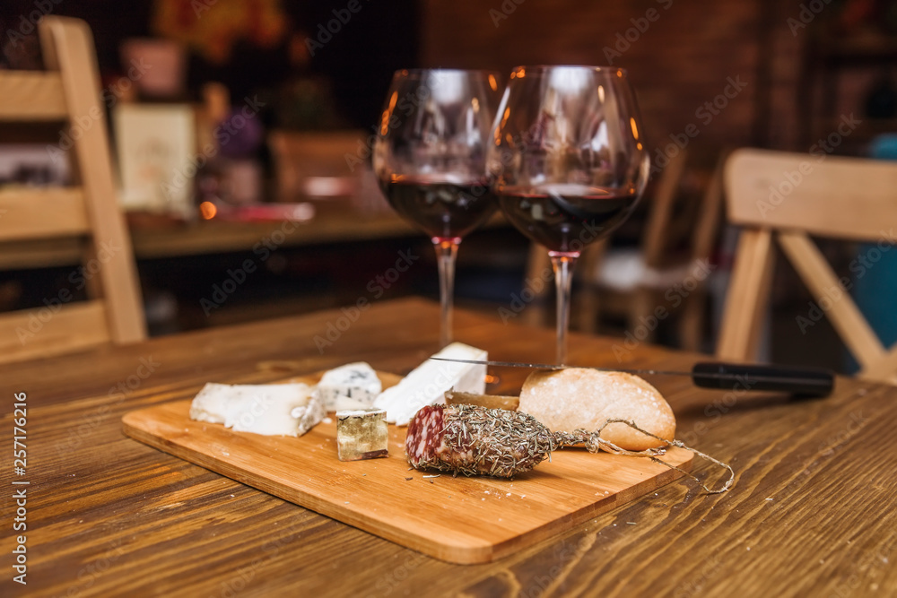 Red wine and assorted cheese plate with sausage