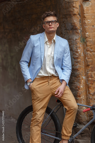 Stylish young man posing on the street on a retro bike. photo