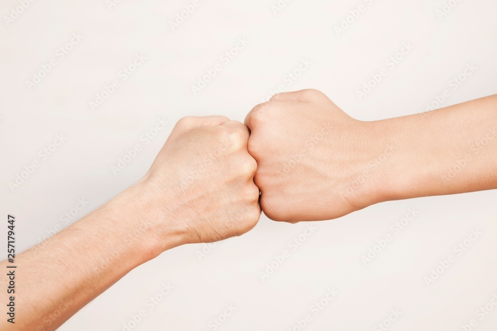 One fist against another on a light background. Concept of struggle, competition One fist against another on a light background. Concept of struggle, competition