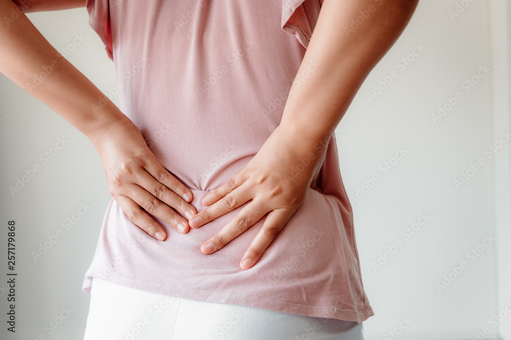 custom made wallpaper toronto digitalClose-Up of Woman Hands is Massaging Her Waist on Isolated Gray Background, Young Adult having Backache After Home Work. Healthcare and Medicine Concept.