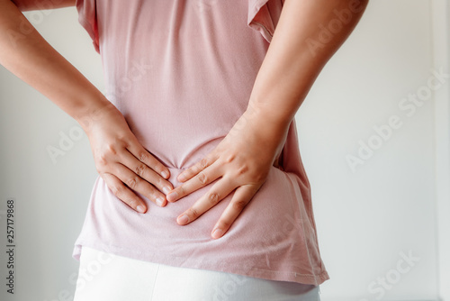 Wallpaper Mural Close-Up of Woman Hands is Massaging Her Waist on Isolated Gray Background, Young Adult having Backache After Home Work. Healthcare and Medicine Concept. Torontodigital.ca