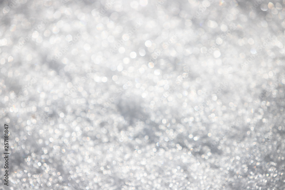 White silvery texture of defocused snow. Bright spotted bokeh. White silvery texture of defocused snow. Bright spotted bokeh.
