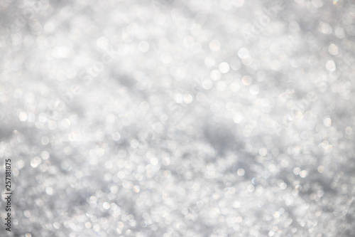 White silvery texture of defocused snow. Bright spotted bokeh.