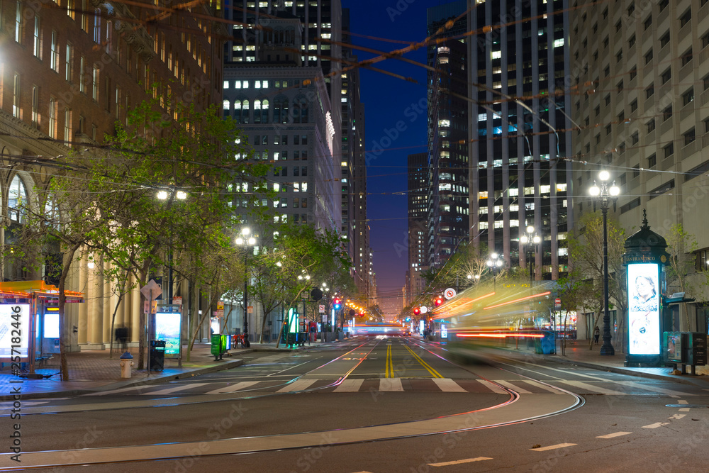 Market Street with it's tram lines and skyscrapers at dusk with street lights trails from moving vehicles in San Fransisco, US