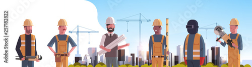 construction workers team industrial technicians builders group over city construction site tower cranes building residential buildings cityscape background flat horizontal portrait