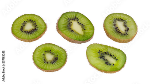 Green kiwi fruit slices. Fuzzy kiwifruit. Actinidia deliciosa. Isolated on white background. Group of sliced bio kiwis close-up. Brown skin and black seeds. Set of sweet-sour parts of tropical berry.