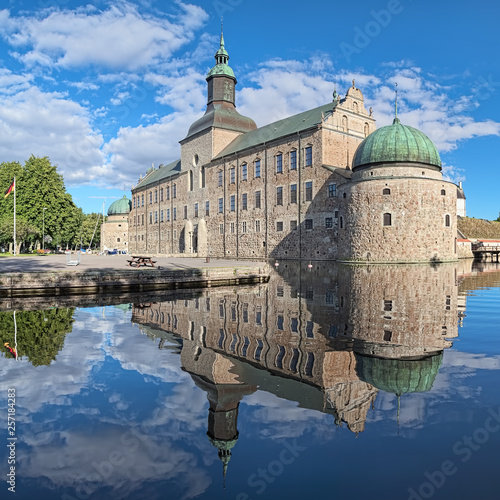 Vadstena Castle in the city of Vadstena, Sweden. The main castle building reflects in the water of moat. Construction of the castle was started in 1545. The castle was completed in 1620.