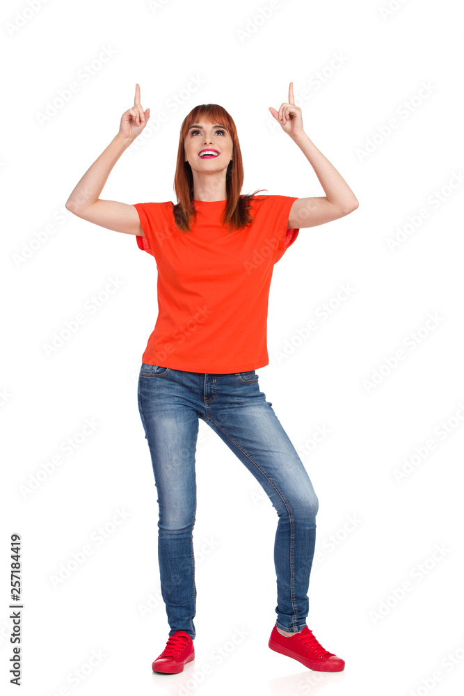 Happy Young Woman Is Pointing Above Her Head And Looking Up Happy Young Woman Is Pointing Above Her Head And Looking Up