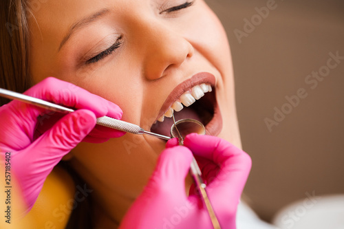 Fototapeta Naklejka Na Ścianę i Meble -  Close up picture of a young blonde beautyful patient's mouth during examination of teeth at the dentist