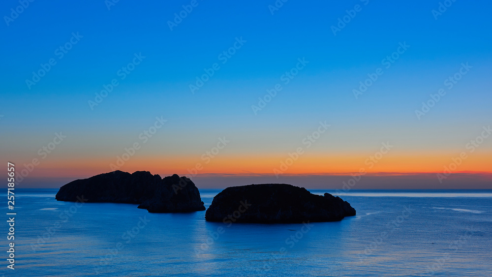 blue waters under a blue sky at sunset with the Malgrats Islands, Majorca,.Balearic Islands, Spain