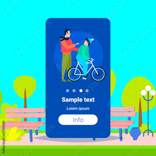 father and son learning to ride a bicycle outdoor man teaching boy cycling bike family having fun together city urban park landscape background flat copy space
