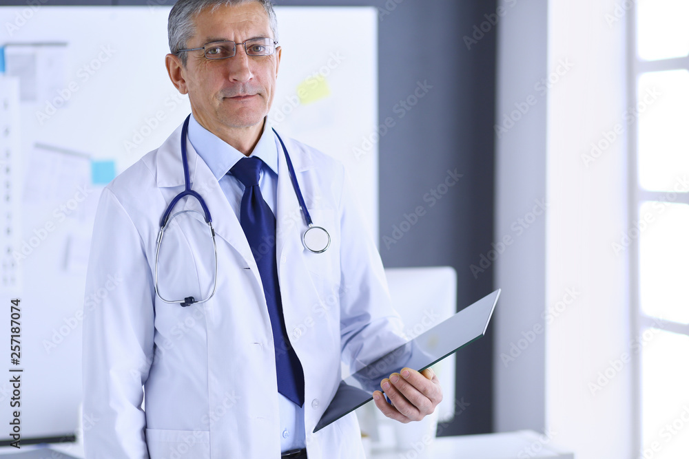 Male doctor writes notes on the clipboard in the hospital Male doctor writes notes on the clipboard in the hospital