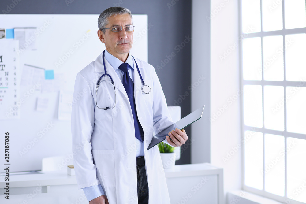 Male doctor writes notes on the clipboard in the hospital Male doctor writes notes on the clipboard in the hospital