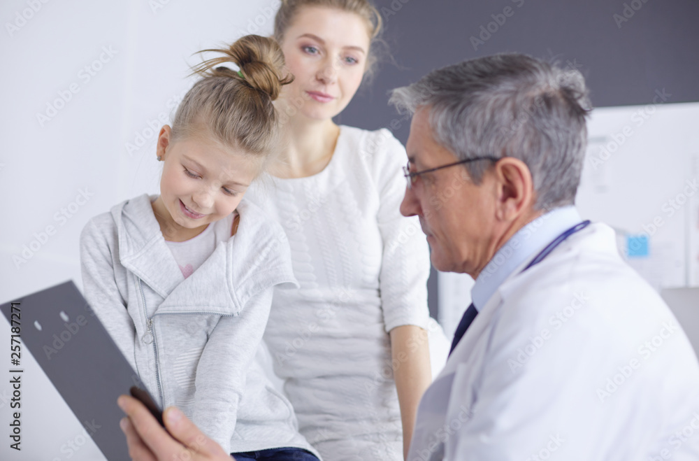 Fototapeta premium Little girl with her mother at a doctor on consultation