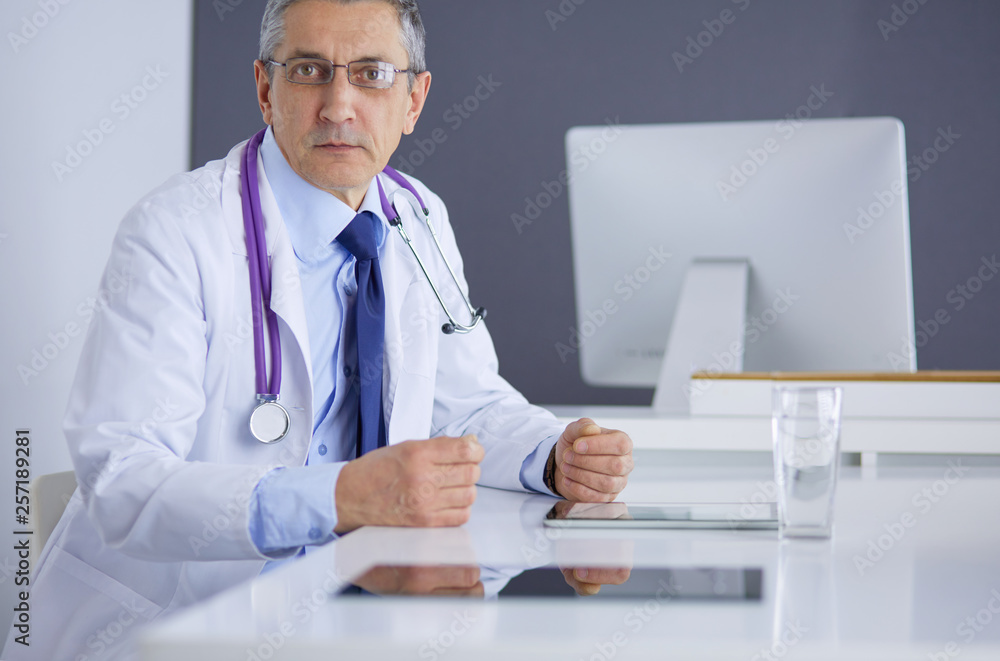 Portrait of senior doctor sitting in medical office Portrait of senior doctor sitting in medical office
