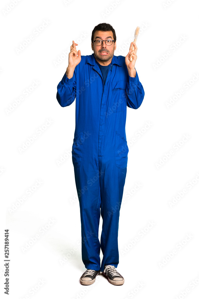 A full-length shot of a Painter man with fingers crossing and wishing the best on isolated white background A full-length shot of a Painter man with fingers crossing and wishing the best on isolated white background