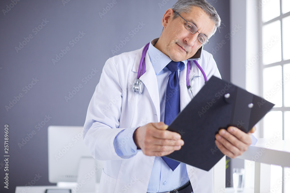 Male doctor writes notes on the clipboard in the hospital Male doctor writes notes on the clipboard in the hospital