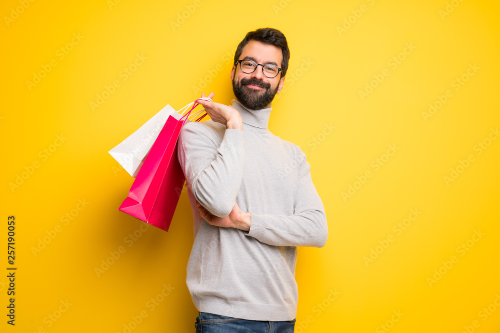 Man with beard and turtleneck holding a lot of shopping bags Man with beard and turtleneck holding a lot of shopping bags