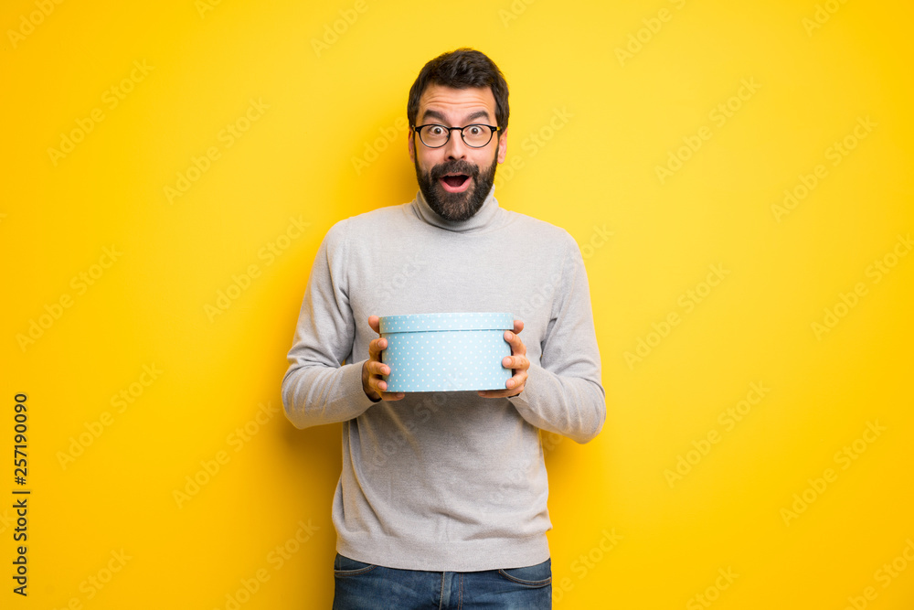 Man with beard and turtleneck surprised because has been given a gift Man with beard and turtleneck surprised because has been given a gift