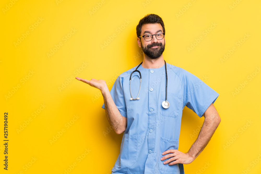 Surgeon doctor man holding copyspace imaginary on the palm to insert an ad Surgeon doctor man holding copyspace imaginary on the palm to insert an ad