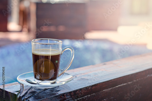 A cup of espresso and a pool in the background. Morning coffee. Summer Breakfast.